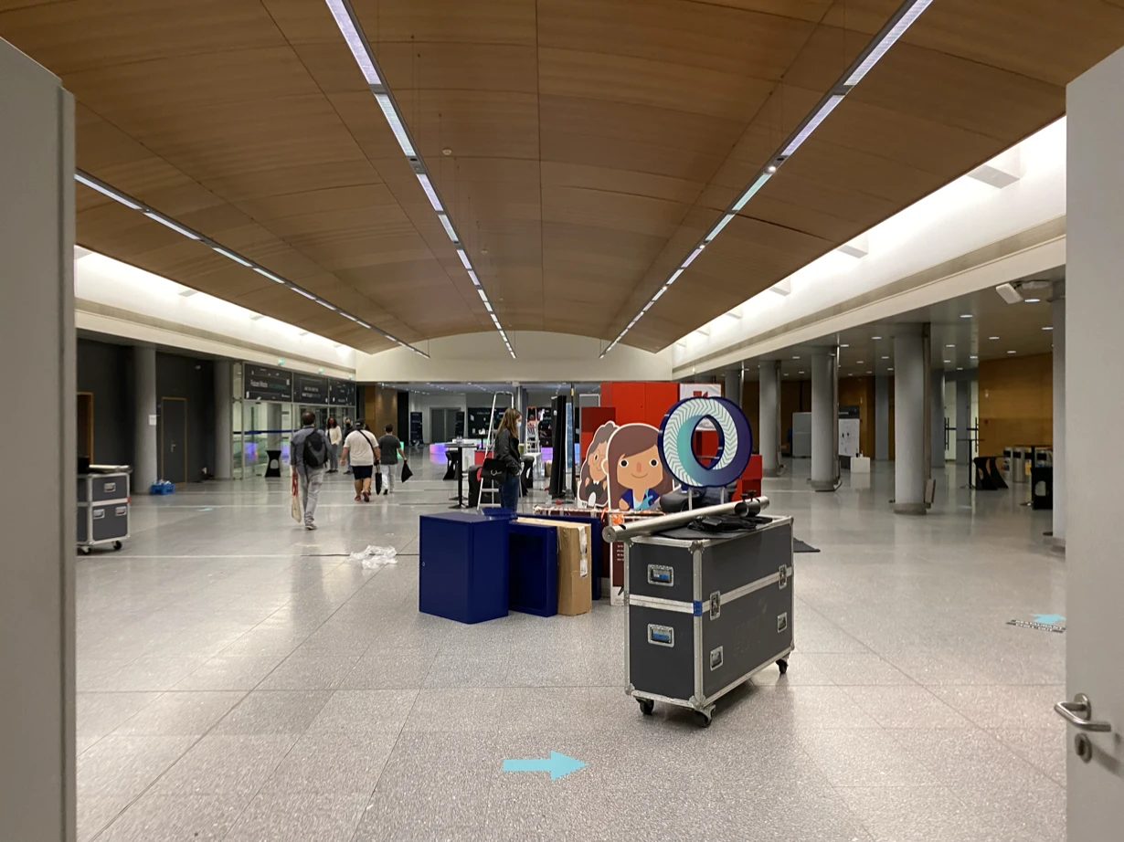 Equipment cases and display stands being removed from an otherwise empty conference hall